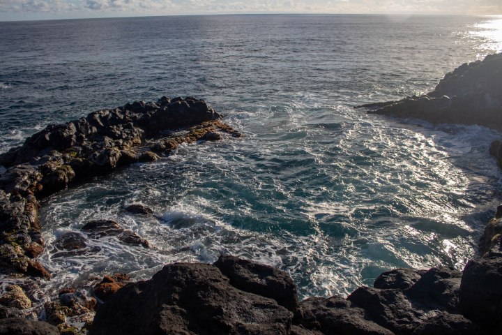 The sun rising over Queen's Bath, Kauai, Hawaii.