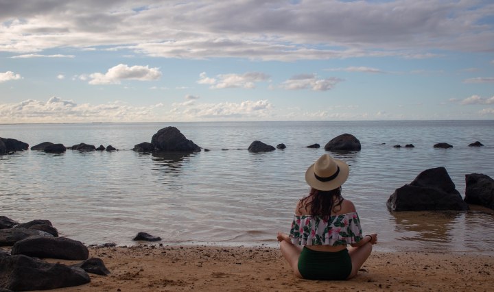 Finding a moment of peace while meditating to the sound of the gentle waves in Hawaii.